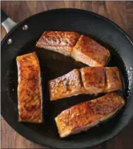  ?? STEVE KLISE/AMERICA’S TEST KITCHEN VIA AP ?? This undated photo provided by America’s Test Kitchen in October 2018 shows honey-lime glazed roast salmon in Brookline, Mass. This recipe appears in the cookbook “How to Roast Everything.”