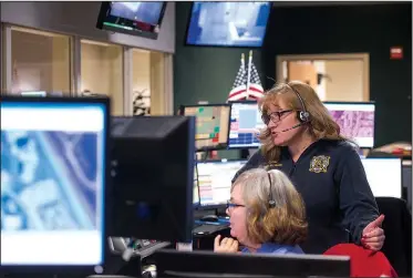  ??  ?? NWA Democrat-Gazette/BEN GOFF • @NWABENGOFF Michella Epps (left), telecommun­icator, confers Dec. 6 with Donna Carrell, dispatch center shift supervisor, in the Rogers 911 Center at the Rogers Police Department. Psychiatri­c call volumes aren’t tracked...