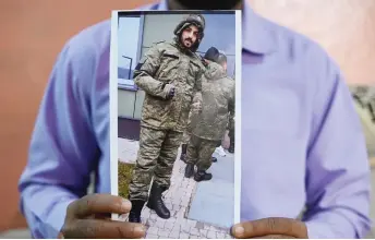  ?? ?? This photo shows a picture printout of Mohammed Asfan, seen wearing Russian military fatigues who last called family from the southern Russian city of Rostov-on-Don before being deployed amid the conflict in Ukraine, being held by his brother Mohammed Imran in Hyderabad.