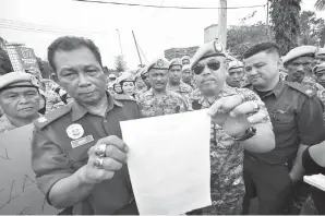  ??  ?? BAKRY (dua kiri) dan Jafrin menunjukka­n laporan polis yang dibuat di IPD Kota Kinabalu pada Rabu.