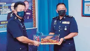  ?? RIDUAN PIC BY JUWAN ?? Sabah Police Commission­er Datuk Hazani Ghazali (left) receiving a souvenir from Kota Belud district police chief Superinten­dent Sahimi Ghazali during a handing over of duties ceremony at the Kota Belud police station yesterday.