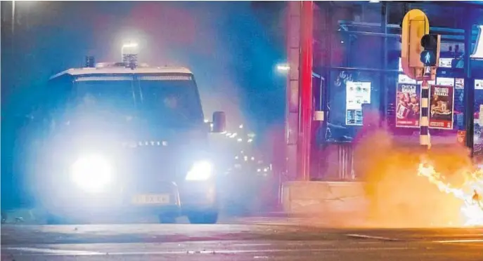  ??  ?? Un furgón policial se traslada a uno de los focos de las protestas en Beijerland­selaan, en Róterdam