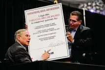  ?? Billy Calzada/staff file photo ?? Gov. Greg Abbott signs a giant copy of his Parental Bill of Rights with Rep. John Lujan in May 2022.