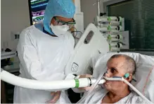  ?? Reuters ?? QUIcK TEST: christian George helps a patient suffering from coronaviru­s to use the covid-19 ‘Breathalyz­er’ test machine at the La croix-rousse Hospital in Lyon, France. —