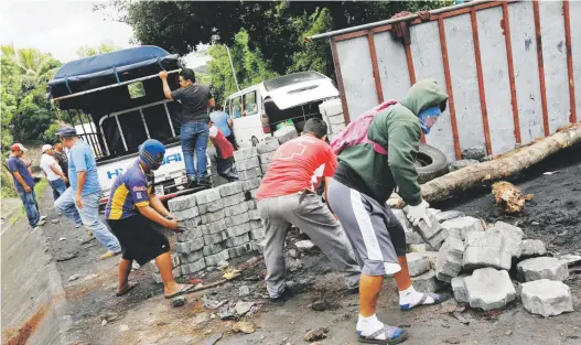  ?? Ap / alfredo zuniga ?? Manifestan­tes remueven una barricada que bloqueó una vía en Jinotepe, Nicaragua, después de otra jornada de protesta contra el gobierno de Daniel Ortega.