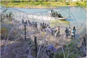  ?? ERIC GAY/ASSOCIATED PRESS ?? Migrants who crossed into the U.S. from Mexico are met with concertina wire along the Rio Grande in Eagle Pass, Texas.