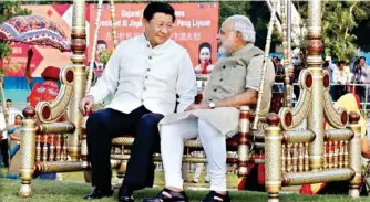  ??  ?? Chinese President Xi Jinping sits on a swing with Indian Prime Minister Narendra Modi at a riverside park in Gujrat in 2014