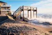  ??  ?? A staircase that once helped beachgoers cross a sand dune in Buxton, North Carolina, is pummelled by the Atlantic.