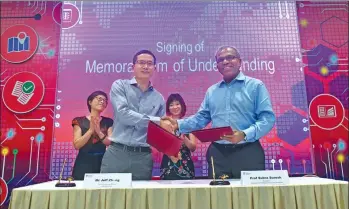  ?? DENG WEIZHI / XINHUA ?? Chief technology officer Zhang Jianfeng of Alibaba (left) and Subra Suresh, president of Nanyang Technologi­cal University in Singapore, shake hands after signing an agreement to jointly launch a research institute in AI technology on Feb 28 in Singapore.