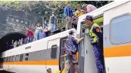  ?? HSNEWS.COMTW VIA ASSOCIATED PRESS ?? Passengers are helped to climb out of the derailed train in eastern Taiwan. They made their way through windows to the top of the train.