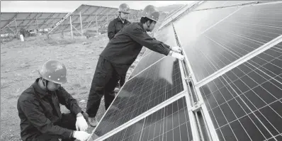  ?? YU JIARUI / FOR CHINA DAILY ?? Technician­s check solar power generation facilities in Datong, Shanxi province.