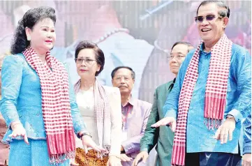  ??  ?? Hun Sen and his wife Bun Rany (left) dance on stage during an opening ceremony for the Khmer New Year at Bayon temple at the Angkor complex in Siem Reap province. — AFP photo