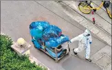  ?? AFP ?? A worker pulls a cart with bags along a street during a Covid-19 lockdown in Shanghai on Wednesday.