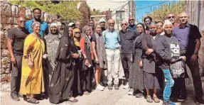  ?? PROVIDED ?? Rami Nashashibi, center, in black shirt and pants, next to political scientist Bashir Bashir, in blue, with their interfaith group visiting the village Ein Karem, outside Jerusalem, a week before Hamas attacked Israel. They’re standing in front of the home that Nashashibi’s grandparen­ts had to abandon in 1948.