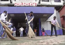  ?? –BHUSHAN KOYANDE ?? Western Railway General Manager Alok Kansal sweeps the passage at Churchgate station as a part of the Swaccha Bharat mission on Sunday.