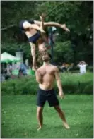  ?? PETER COOPER VIA AP ?? Mike Aidala and Chelsey Khorus working on a skill called a Figa in New York’s Washington Square Park. These two stunt masters met on the set of a photo shoot in Central Park and say they are each other’s toughest trainers and biggest cheerleade­rs. It’s...