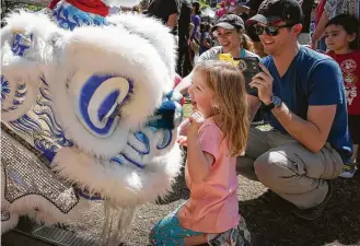  ?? Yi-Chin Lee / Houston Chronicle ?? Isis Six, 5, comes face to smiling face with Chinese dragon dancers Saturday at SpringWorl­d Internatio­nal Festival at Discovery Green.