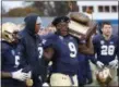  ?? TIM PHILLIS — THE NEWS-HERALD ?? John Carroll’s Ray Brown celebrates with the Cuyahoga Gold Bowl trophy Nov. 10. The Blue Streaks defeated Baldwin Wallace, 45-35.