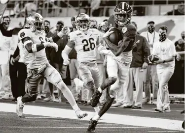  ?? Michael Ainsworth / Associated Press ?? AlabamaWR DeVonta Smith outruns Notre Dame LB Jeremiah Owusu-Koramoah (6) and CB Clarence Lewis on his way to the end zone. Smith caught three of fellow Heisman finalist Mac Jones’ four TD passes.