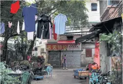  ??  ?? BELOW Awoman walks through the traditiona­l neighbourh­ood of Yuexiu.