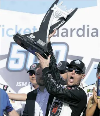  ?? Rick Scuteri/Associated Press ?? Kevin Harvick hoists his trophy after holding off Kyle Busch to win the race Sunday in Avondale, Ariz., his third victory in a row.