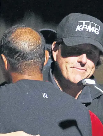  ?? ASSOCIATED PRESS ?? WELL WORTH IT: Phil Mickelson hugs Tiger Woods after their golf match yesterday at Shadow Creek in Las Vegas. Mickelson won the match in 22 holes, along with $9 million in the pay-per-view event.