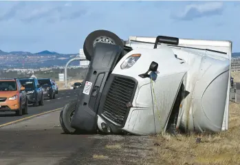  ?? CHRISTIAN MURDOCK/THE GAZETTE ?? Blown over: A semitruck lies on its side Friday morning on an interstate north of Colorado Springs, Colo. According to a National Weather Service meteorolog­ist based in Pueblo, Colorado, a 105-mph wind gust was recorded Friday in southwest Colorado Springs. Gusts ranging from 46 mph to 95 mph were also recorded across the state.