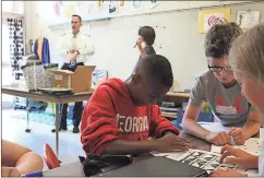  ?? Spencer Lahr / Rome News-Tribune ?? Johnson Elementary School Kaleidosco­pe class fifth-graders Braxton Redwine (from left) works on his team’s paper airplane while Austin Sheppard and Georgia Hibberts watch during the Adopt-A-Pilot program.