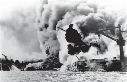  ??  ?? The infamous Japanese attack on Pearl Harbor, Hawaii, is shown in this Dec. 7, 1941, photo. The USS Arizona is pictured in flames after being hit.
