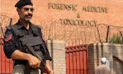  ?? Photograph: Bilawal Arbab/EPA ?? A Pakistani police officer stands guard outside a mortuary where the body of Tahir Ahmad Naseem was taken.