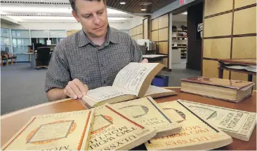  ??  ?? Stephen Ross from the University of Victoria’s English department, flips through some rare editions of James Joyce’s once-banned Ulysses at the university’s special-collection­s library in 2013.