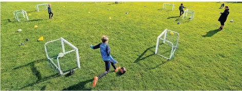 ?? FOTO: ROBERT MICHAEL/DPA ?? Auf Abstand: Fußballer der Altersklas­se U-10 trainieren auf dem Spielfeld mit Distanz.