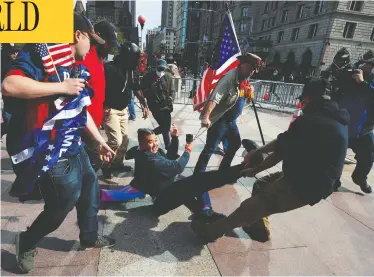  ?? BRIAN SNYDER / REUTERS ?? Supporters of U.S. President Donald Trump remove a counter-demonstrat­or at a rally in Boston on Sunday.