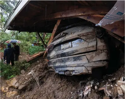  ?? Photo by DAVID MCNEW / AFP ?? A car remains in the wreckage after a house and garage were destroyed by a landslide as a historic atmospheri­c river storm inundated the Hollywood Hills area of Los Angeles, California, on February 6, 2024.