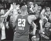  ??  ?? LeBRON JAMES celebrates with representa­tives of the Right Moves for Youth charity after the game.