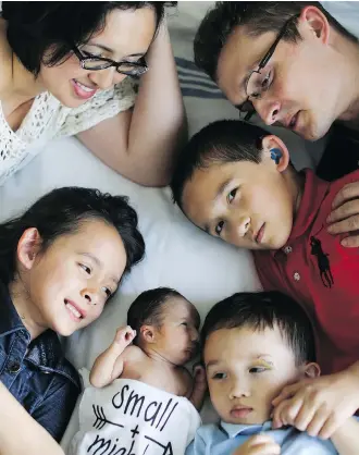  ??  ?? The Kmiec family surrounds little Lucy-Rose, who was born with trisomy 13 and lived a short but wonderful 39 days. From top left: mom Evangeline, dad Tom, sister Jolie, 7, brothers Maximillio­n, 10 and Enoch, 3.