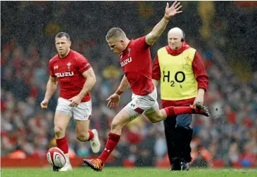  ?? AP ?? Wales’ Gareth Anscombe kicks a goal in his 20-point haul while at left, Wales captain Alun Wyn Jones with the Six Nations trophy after their 25-7 win over Ireland.