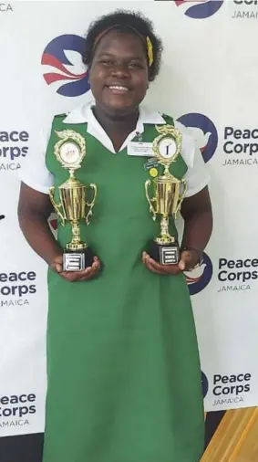  ?? ?? Kasheka Grant displays her trophies after placing first and second in the Social Developmen­t Commission and Peace Corps Poster and Public Speaking Competitio­n.