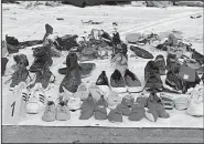  ?? AP/TATAN SYUFLANA ?? Shoes and other personal belongings pulled from the water where a Lion Air jet is believed to have crashed are displayed Wednesday for people to identify at the Port of Tanjung Priok in Jakarta, Indonesia.