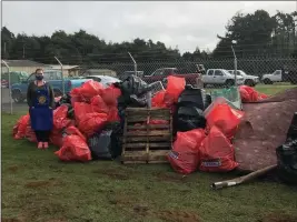  ?? MENDOCINO COUNTY SHERIFF’S OFFICE — CONTRIBUTE­D ?? A volunteer stand with the piles of garbage pulled out from the Hare Creek homeless encampment.