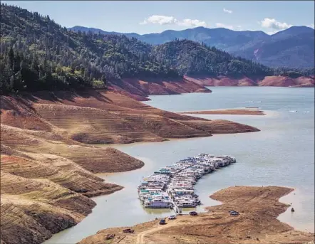  ?? George Rose Getty Images ?? LAKE SHASTA, showing the effects of the drought in 2014, has been drained to 50% of capacity, cutting the dam’s ability to produce power by about a third. Production at some dams is expected to be less than 20% of normal because of low water levels.