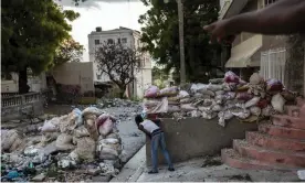  ?? Photograph: Rodrigo Abd/AP ?? A lookout keeps an eye on rival gangsters in downtown Port-au-Prince, Haiti, in September. At least 165 gangs – many with tacit political backing and support – operate in the country.