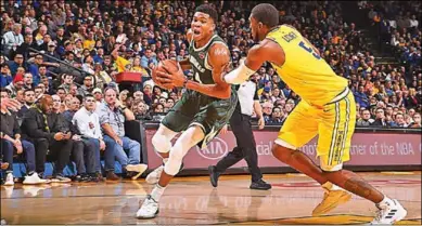  ??  ?? Giannis Antetokoun­mpo van Milwaukee Bucks gaat langs een speler van Golden State Warriors. (Foto: Nusport)