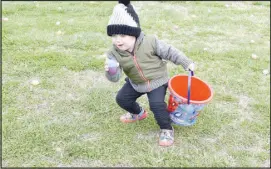  ?? ?? Nathaniel Woolheater, 2, hurries to pick up eggs on the square.
