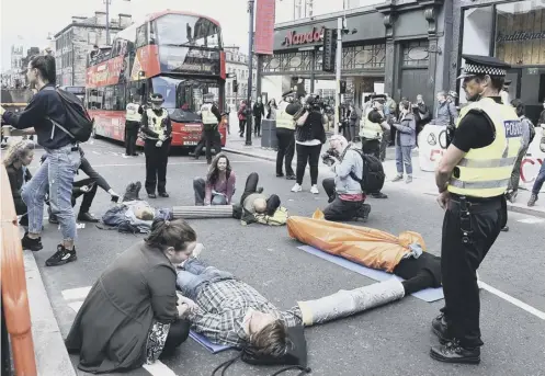  ??  ?? 0 Activists from Extinction Rebellion Scotland chained themselves together on Edinburgh’s Lothian Road