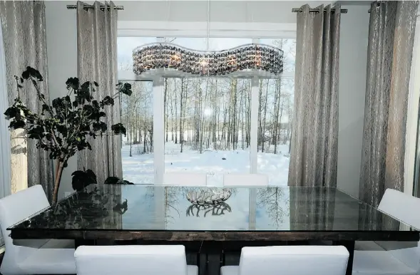  ?? Photos: Bruce Edwards/Edmonton Journal ?? Delicate silk curtains frame an ever-changing view from the breakfast nook, where the Rayners often dine at the barnwood-topped table.