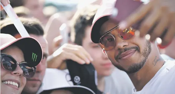  ?? Picture: Getty Images ?? SMILE PLEASE. Mercedes driver Lewis Hamilton poses for a selfie with fans ahead of the Hungarian Grand Prix.