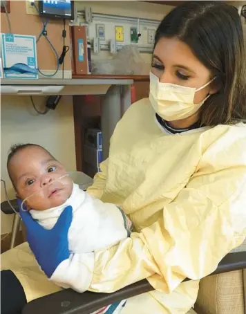  ?? JOE CAVARETTA/SOUTH FLORIDA SUN SENTINEL PHOTOS ?? Nadine Sollak, a neonatal intensive care unit nurse, holds baby Cheyenne Tomblin at West Boca Medical Center on Tuesday. Cheyenne was born in September weighing just 12 ounces, the size of a can of soda.