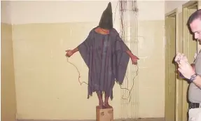  ?? (AP Photo, File) ?? This late 2003 photo obtained by The Associated Press shows an unidentifi­ed detainee standing on a box with a bag on his head and wires attached to him in the Abu Ghraib prison in Baghdad, Iraq. A trial scheduled to begin Monday in U.S. District Court in Alexandria, Va., will be the first time that survivors of Iraq’s Abu Ghraib prison will bring their claims of torture to a U.S. jury. Twenty years ago, photos of abused prisoners and smiling U.S. soldiers guarding them shocked the world.