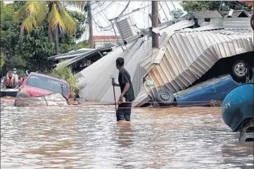  ?? DELMER MARTINEZ/AP ?? A man wades through a flooded street Nov. 6 in Planeta, Honduras, after Hurricane Eta raked parts of Central America.